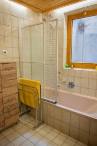 La salle de bains est pourvue d'une chaise jaune à côté d'une baignoire. dans l'établissement FEWO Silberberg TOP 4, à Alpbach 15 autres photos