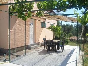 a patio with a table and chairs on it at Apartments Petko in Rogoznica