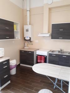 a kitchen with black cabinets and a white table at Csanabella House in Szeged