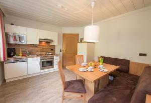 a kitchen and dining room with a table and a couch at Kramerhaus Viehhofen in Viehhofen