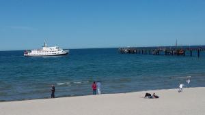 a boat in the ocean with people on the beach at Apartments zum Brauergang in Garz