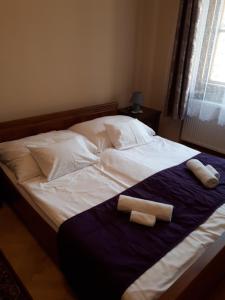 Una cama con dos toallas enrolladas. en Csanabella House, en Szeged
