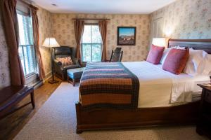 1 dormitorio con 1 cama y 1 silla en una habitación en Gay Street Inn, en Washington, Virginia