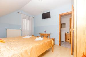 een slaapkamer met een groot bed en een tafel bij Guesthouse Kaučič in Benedikt v Slovenskih Goricah