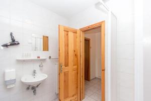 a bathroom with a sink and a wooden door at Guesthouse Kaučič in Benedikt v Slovenskih Goricah