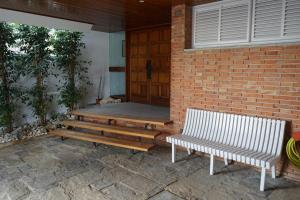 dos bancos sentados en el porche de una casa en Apartamentos Les Barbes, en Caldes d'Estrac