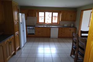 a kitchen with wooden cabinets and a white refrigerator at 14 Drumcoura Lake Resort in Ballinamore