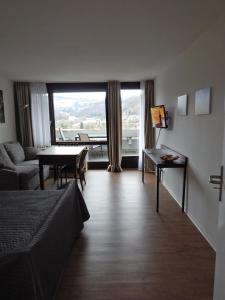 een woonkamer met een bed, een tafel en een raam bij FREE Apartment - Schönblick in Bad Urach