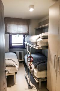 a room with two bunk beds and a window at Residence Des Alpes in Canazei