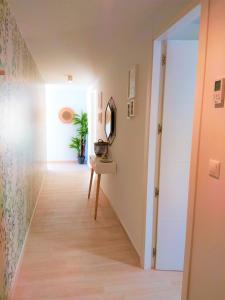 a hallway with a mirror and a table with a mirror at Luxury and Modern Beach Apartment with Sea Views in La Mata