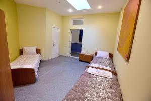 two beds in a room with yellow walls at Saint Paul Odessa in Odesa