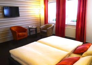 リューデスハイム・アム・ラインにあるホテル ツム ベーレンのベッド2台、薄型テレビが備わるホテルルームです。