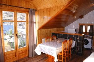 a dining room with a table in a wooden house at Apartaments Pont Romànic in Espot