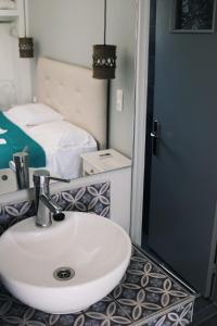 a bathroom with a sink and a bed at Esperida rooms & studios in Amoopi