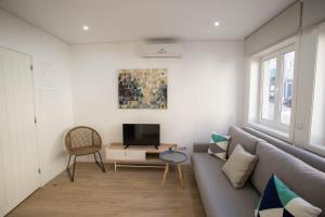 een woonkamer met een bank en een tv bij Camões 691 Design Apartments by Porto City Hosts in Porto
