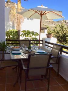 - une table avec un parasol sur la terrasse dans l'établissement Vista Marina, à La Herradura