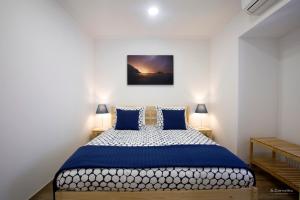 ein Schlafzimmer mit einem großen Bett mit blauen Kissen in der Unterkunft Casa das Sardinhas in Setúbal