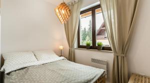sypialnia z łóżkiem i oknem w obiekcie TWOJA CHATA Apartament pod lasem zarezerwuj na podhalami pl w mieście Kościelisko