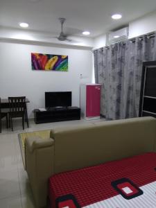 salon z kanapą i telewizorem w obiekcie D'Perdana Apartment 2 w mieście Kota Bharu