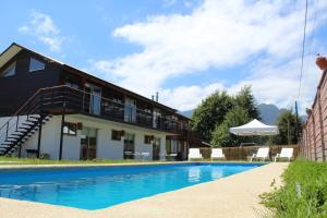 普孔Lackuntur Pucón departamentos的一栋楼前有游泳池的房子