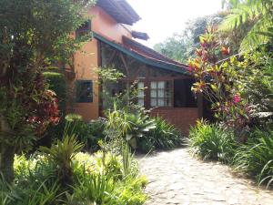 uma casa com um jardim em frente em Pousada Arte de Viver em Lumiar