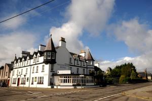 
a large building with a clock on the side of it at Caledonian Hotel 'A Bespoke Hotel’ in Ullapool
