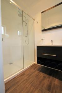 La salle de bains est pourvue d'une douche en verre et d'un lavabo. dans l'établissement Brecon Pond Bed & Breakfast, à Stratford