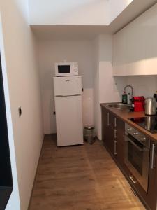 a kitchen with a white refrigerator and a microwave at Silver Poiana Brasov Ap 41 in Poiana Brasov