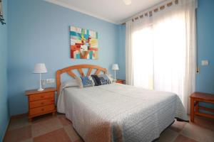 Un dormitorio con una cama y una pared azul. en OLIVA HOLIDAYS 2, en Oliva 30 fotos más