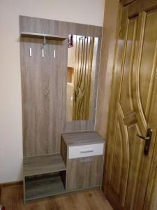 Baño con espejo junto a una puerta de madera en Sadyba Lesivykh, en Slavske