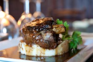 un morceau de viande sur une plaque au-dessus des pommes de terre dans l'établissement Boot & Shoe Inn, à Greystoke