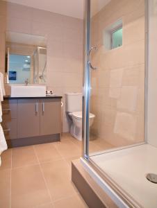 a bathroom with a shower and a sink and a toilet at Breakwater Motel in Paihia