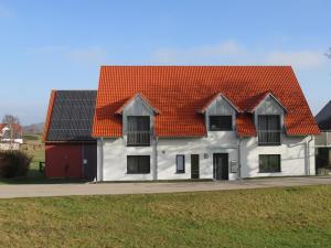 una casa blanca con techo naranja en Ferienwohnung I en Schnelldorf