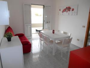 ガリポリにあるCasa vacanza Le Vele Gallipoli Baia Verdeのリビングルーム(白いテーブル、赤いソファ付)