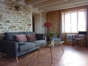 a living room with a couch and a glass table at Le Pilleur d'Epaves in Cléden-Cap-Sizun