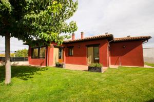 una casa roja con un patio verde en Casa Rural La Guea de Teruel en Teruel