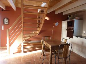 a kitchen and dining room with a wooden table and a staircase at Le Pilleur d'Epaves in Cléden-Cap-Sizun