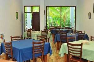 a restaurant with tables and chairs with blue tables at Aliya Lanka in Beruwala