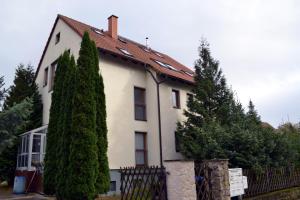 ワイマールにあるFerienwohnung Alexanderの塀と木の白い家