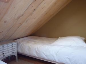 a bedroom with a bed and a wooden ceiling at Le Pilleur d'Epaves in Cléden-Cap-Sizun