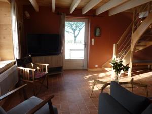 a living room with a staircase and a television at Le Pilleur d'Epaves in Cléden-Cap-Sizun