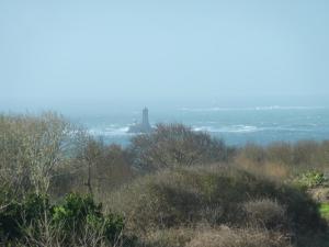 a distant view of a lighthouse in the distance at Le Pilleur d'Epaves in Cléden-Cap-Sizun