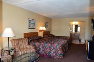 ターポン・スプリングスにあるTarpon Shores Innのベッドと椅子付きのホテルルーム