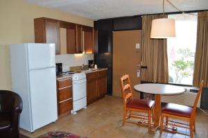 a kitchen with a table and a white refrigerator at Tarpon Shores Inn in Tarpon Springs
