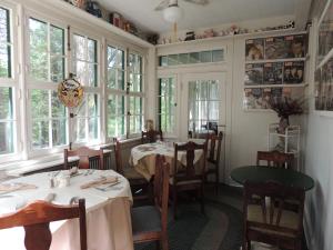 a dining room with tables and chairs and windows at Brookview Manor Inn in Canadensis