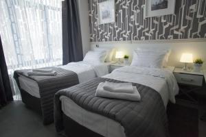 two beds in a hotel room with towels on them at Metro Hotel in Shchëkino