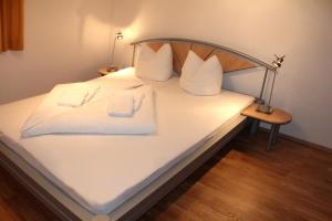 a white bed with two white towels on it at Haus Ganahl in Vandans