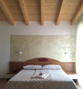 トレモージネ・スル・ガルダにあるAgriturismo Al Franetのベッドルーム1室(ベッド1台、2皿付)