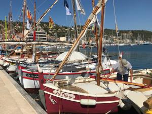 un homme debout sur un voilier dans un port dans l'établissement Maison de pêcheur 1900, à Saint-Mandrier-sur-Mer