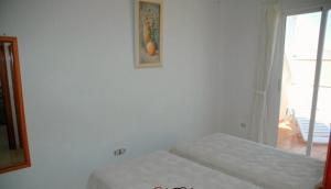 sypialnia z 2 łóżkami i zdjęciem na ścianie w obiekcie One-bedroom flat 200m from the beach w mieście Almería